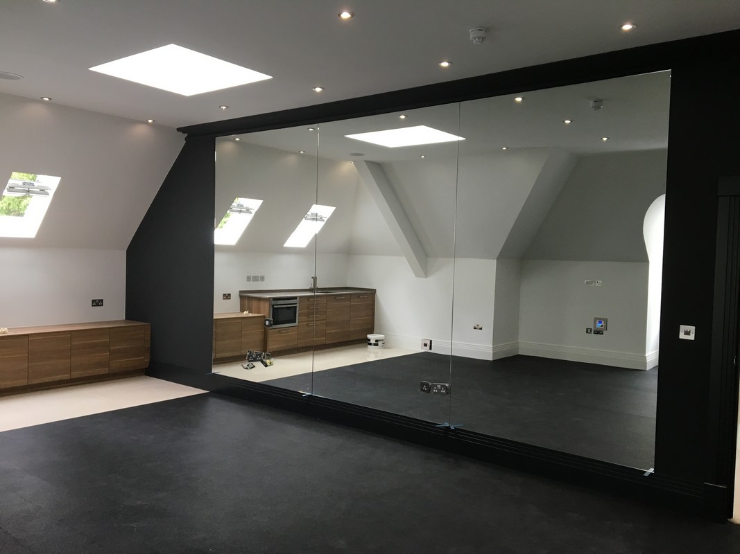 Frameless glass wall dividing loft conversion in Kensal Green